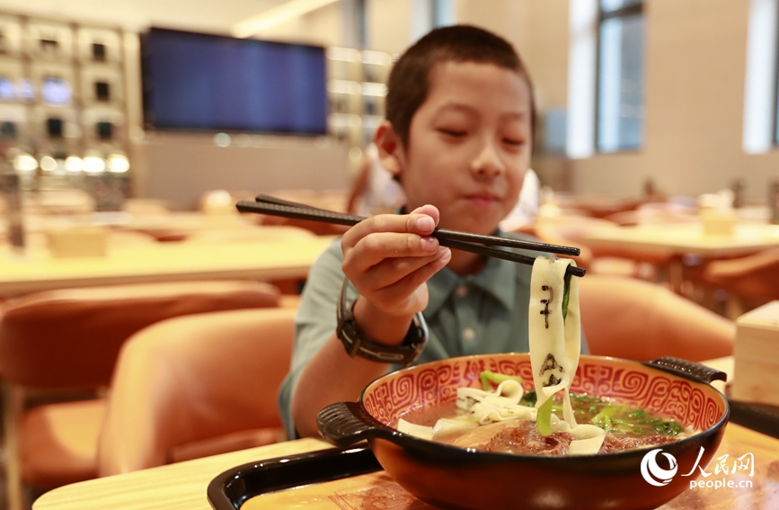 殷墟博物館推出的甲骨文面深受游客喜愛。人民網(wǎng)記者 慎志遠 攝