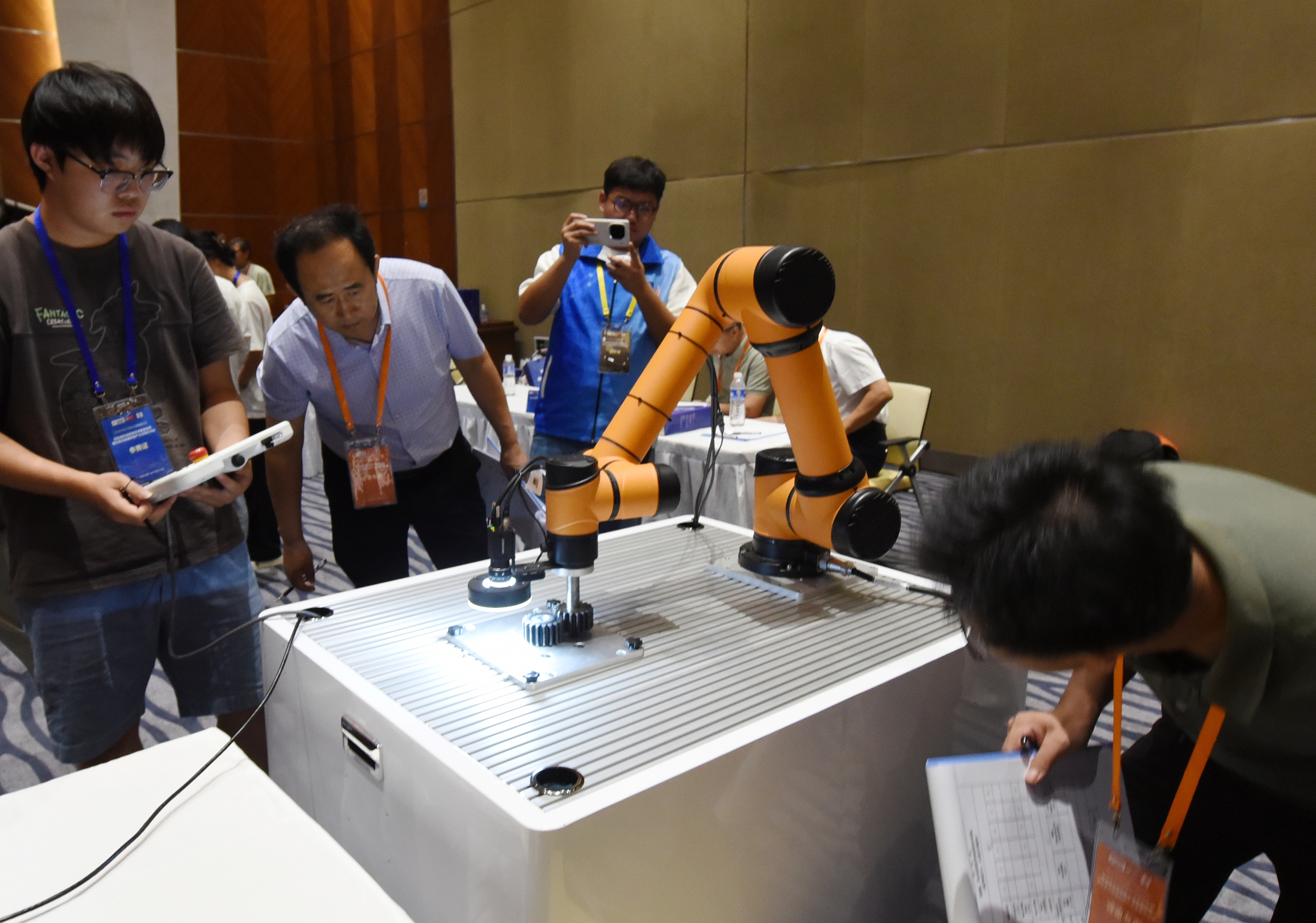 2025年中國大學(xué)生機(jī)械工程創(chuàng)新創(chuàng)意大賽智能精密裝配賽京津冀魯聯(lián)賽現(xiàn)場，評委對參賽選手進(jìn)行實(shí)操調(diào)試評比。